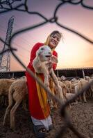 Vietnamese woman with lamb on a countryside, a sheep farm in the steppe zone in Ninh Thuan Province, Vietnam. photo