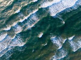 Oceano olas en el playa como un antecedentes. aéreo parte superior abajo ver de playa y mar con azul agua ondas. Vietnam playa foto