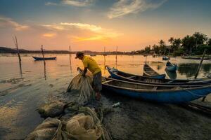 Traditional fishermen and boats in O Loan lagoon during sunset, Phu Yen province, Vietnam. Travel and landscape concept photo