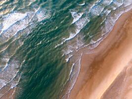 Oceano olas en el playa como un antecedentes. aéreo parte superior abajo ver de playa y mar con azul agua ondas. Vietnam playa foto