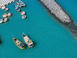 Aerial view of Loc An fishing village, Vung Tau city. A fishing port with tsunami protection concrete blocks. Cityscape and traditional boats in the sea. photo