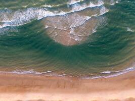 Oceano olas en el playa como un antecedentes. aéreo parte superior abajo ver de playa y mar con azul agua ondas. Vietnam playa foto