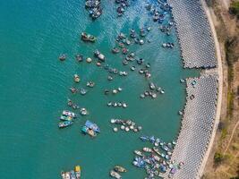 Aerial view of Loc An fishing village, Vung Tau city. A fishing port with tsunami protection concrete blocks. Cityscape and traditional boats in the sea. photo