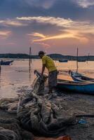 Traditional fishermen and boats in O Loan lagoon during sunset, Phu Yen province, Vietnam. Travel and landscape concept photo