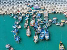 Aerial view of Loc An fishing village, Vung Tau city. A fishing port with tsunami protection concrete blocks. Cityscape and traditional boats in the sea. photo