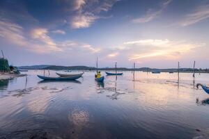 Traditional fishermen and boats in O Loan lagoon during sunset, Phu Yen province, Vietnam. Travel and landscape concept photo