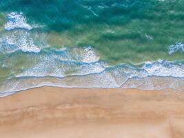 Oceano olas en el playa como un antecedentes. aéreo parte superior abajo ver de playa y mar con azul agua ondas. Vietnam playa foto