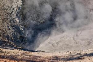 Mud volcano in the morning hours of early fall with steam and bubbles photo