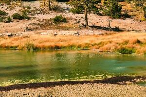 Colorful hot spring bubbling on a cool autumn morning in Yellowstone National Park photo