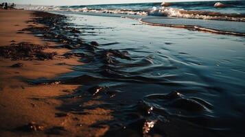 Thick oil slick on the seashore. Waves bring more and more fuel oil to the sandy shore. photo