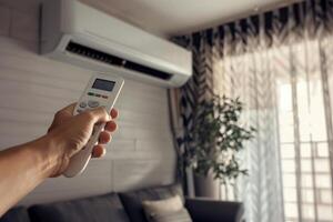 hand with remote control of air conditioner, photo