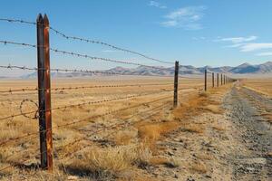 A closeup of the barbed wire on top of an outdoor fence symbolizing security and protection photo