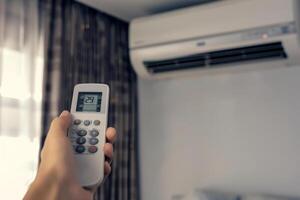 hand with remote control of air conditioner, photo