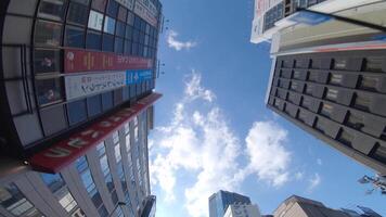 un Moviente paisaje urbano de el edificios a el céntrico en akihabara tokio bajo ángulo video