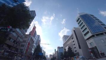 en rör på sig stadsbild på de stadens centrum i shinjuku tokyo förbi låg vinkel video