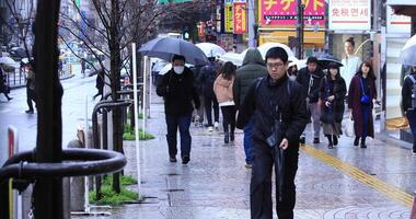 Gehen Menschen Körper Teile beim das Kreuzung im Shinjuku Tokyo regnerisch Tag video