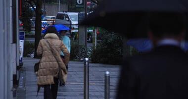 Walking people body parts at the crossing in Shinjuku Tokyo rainy day video