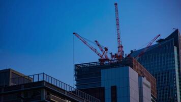 A timelapse of cranes at the under construction behind the blue sky in Tokyo video