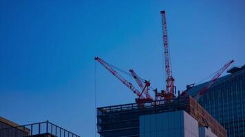 une laps de temps de grues à le en dessous de construction derrière le bleu ciel dans tokyo video