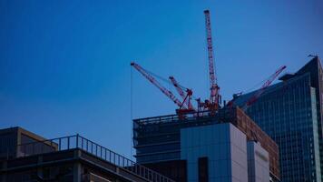 ein Zeitraffer von Kräne beim das unter Konstruktion hinter das Blau Himmel im Tokyo video