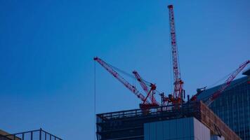 A timelapse of cranes at the under construction behind the blue sky in Tokyo video