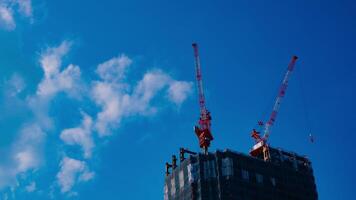 uma espaço de tempo do guindastes às a debaixo construção atrás a azul céu dentro Tóquio video
