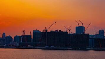 une temps laps de en mouvement grues à le baie zone dans tokyo à crépuscule large coup video