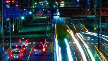 ein Zeitraffer von das Straße beim das Innenstadt im Tokyo beim Nacht lange Exposition Mitte Schuss Zoomen video