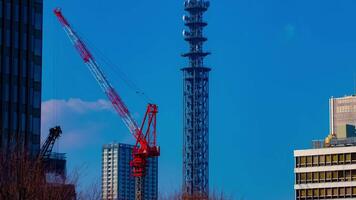 A timelapse of cranes at the under construction behind the blue sky in Tokyo video