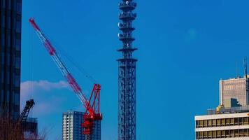 A timelapse of cranes at the under construction behind the blue sky in Tokyo video