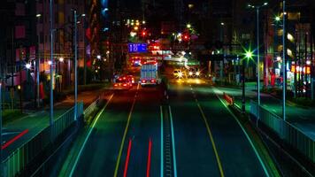 ein Zeitraffer von das Straße beim das Innenstadt im Tokyo beim Nacht lange Exposition Mitte Schuss Zoomen video