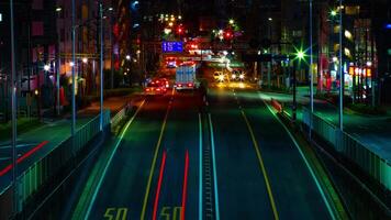 ein Zeitraffer von das Straße beim das Innenstadt im Tokyo beim Nacht lange Exposition Mitte Schuss Neigung video