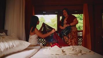 Two women having a conversation in a cozy bedroom with natural light. video