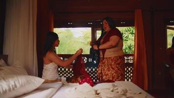 Two women enjoying a leisurely day, one sitting by a window with a serene view, sharing a moment of friendship or relaxation indoors. video