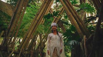 noiva em pé em uma de madeira ponte dentro uma floresta, emoldurado de a arco do galhos. video