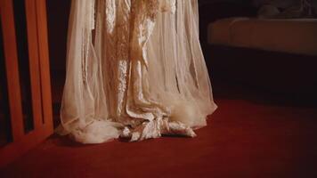 Elegant white bridal gown with lace detailing and a tulle skirt, cascading onto a rich red carpet video