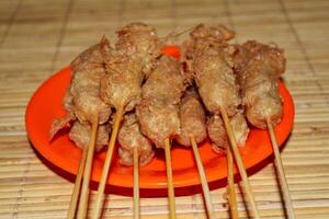 Several skewers of sempolan in a plate photo