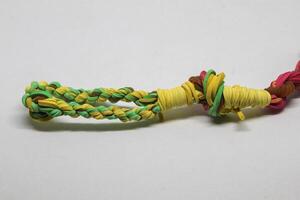 Rubber bands woven into a blowpipe, isolated white photo