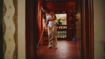 Woman standing in a traditional wooden hallway, with warm lighting and a cozy atmosphere. video