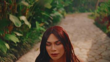 Top view of a young woman with red hair walking on a cobblestone path, capturing a moment of contemplation or solitude. video