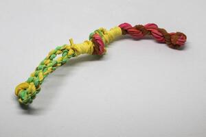 Rubber bands woven into a blowpipe, isolated white photo