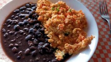 Mexicaans ontbijt door elkaar gegooid eieren met zwart bonen puerto escondido Mexico. video
