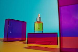 Face oil in glass bottle on yellow and blue background with pink and purple geometric elements photo