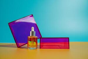 Face oil in glass bottle on yellow and blue background with pink and purple geometric elements photo