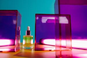 Face oil in glass bottle on yellow and blue background with pink and purple geometric elements and neon light photo