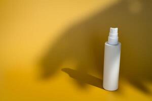 Blank white spray bottle with palm tree shadow photo