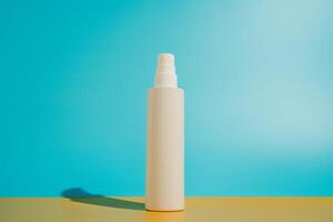 Blank white spray bottle on yellow and blue background in direct sunlight photo