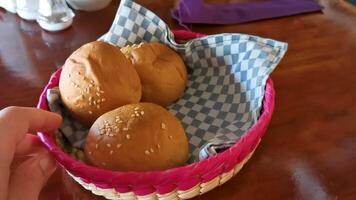 heerlijk ronde broodjes met sesam zaden Aan houten tafel Mexico. video