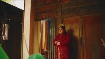 vrouw in traditioneel kleding het uitvoeren van een dans buiten een rustiek gebouw, met groen video