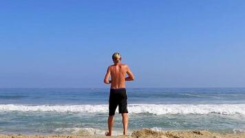 ung man turist med vågor på strand puerto escondido Mexiko. video